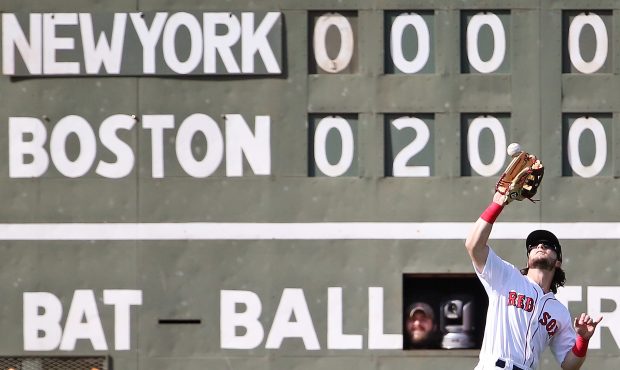 A scorekeeper pops his head out of the Green Monster while Andrew Benintendi (16) of the Boston Red...