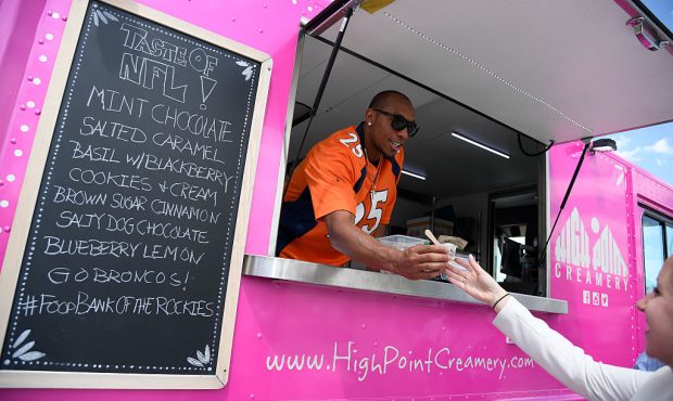Denver Broncos player Chris Harris Jr. scoops ice cream from High Point Creamery and hands it to Li...