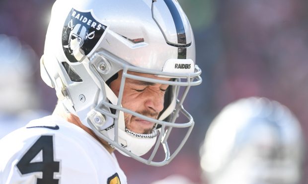 DENVER, CO - DECEMBER 29: Derek Carr (4) of the Oakland Raiders squints on the sidelines during the...
