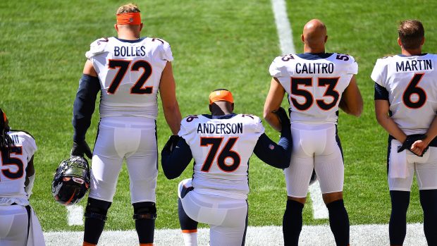 Calvin Anderson #76 joins arms while kneeling for the National Anthem with Garett Bolles #72 and Austin Calitro #53 of the Denver Broncos prior to the game agains the Pittsburgh Steelers at Heinz Field on September 20, 2020 in Pittsburgh, Pennsylvania. (Photo by Joe Sargent/Getty Images)