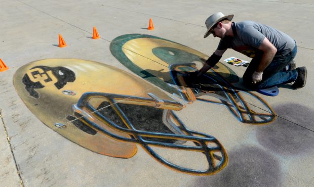 DENVER, CO - SEPTEMBER 1: Chris Carlson works on some sidewalk chalk art prior to the Colorado Buff...