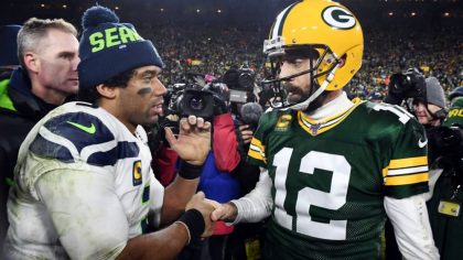 GREEN BAY, WISCONSIN - JANUARY 12: Russell Wilson #3 of the Seattle Seahawks greets Aaron Rodgers #...